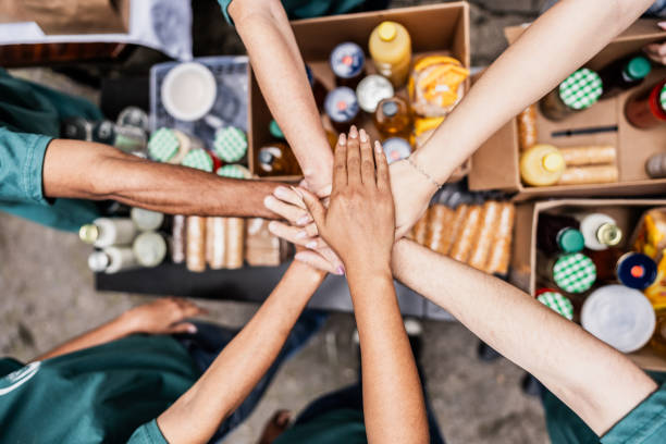 close up of volunteers with hands stacked during donation event outdoors