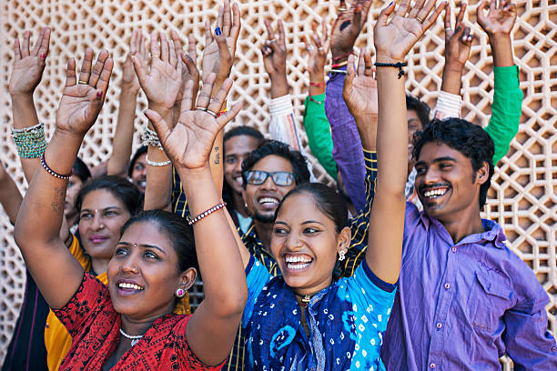 group of indian friends raising hands celebrating holi.